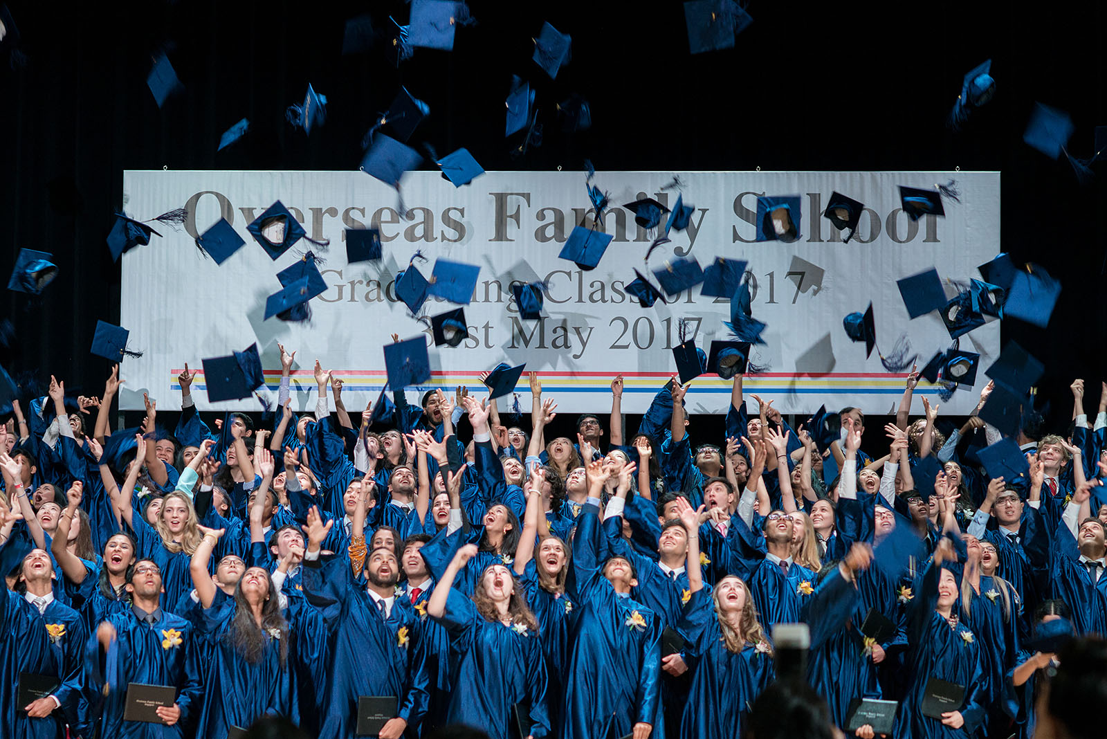 OFS graduates throwing their graduation caps at the end of High School graduation ceremony