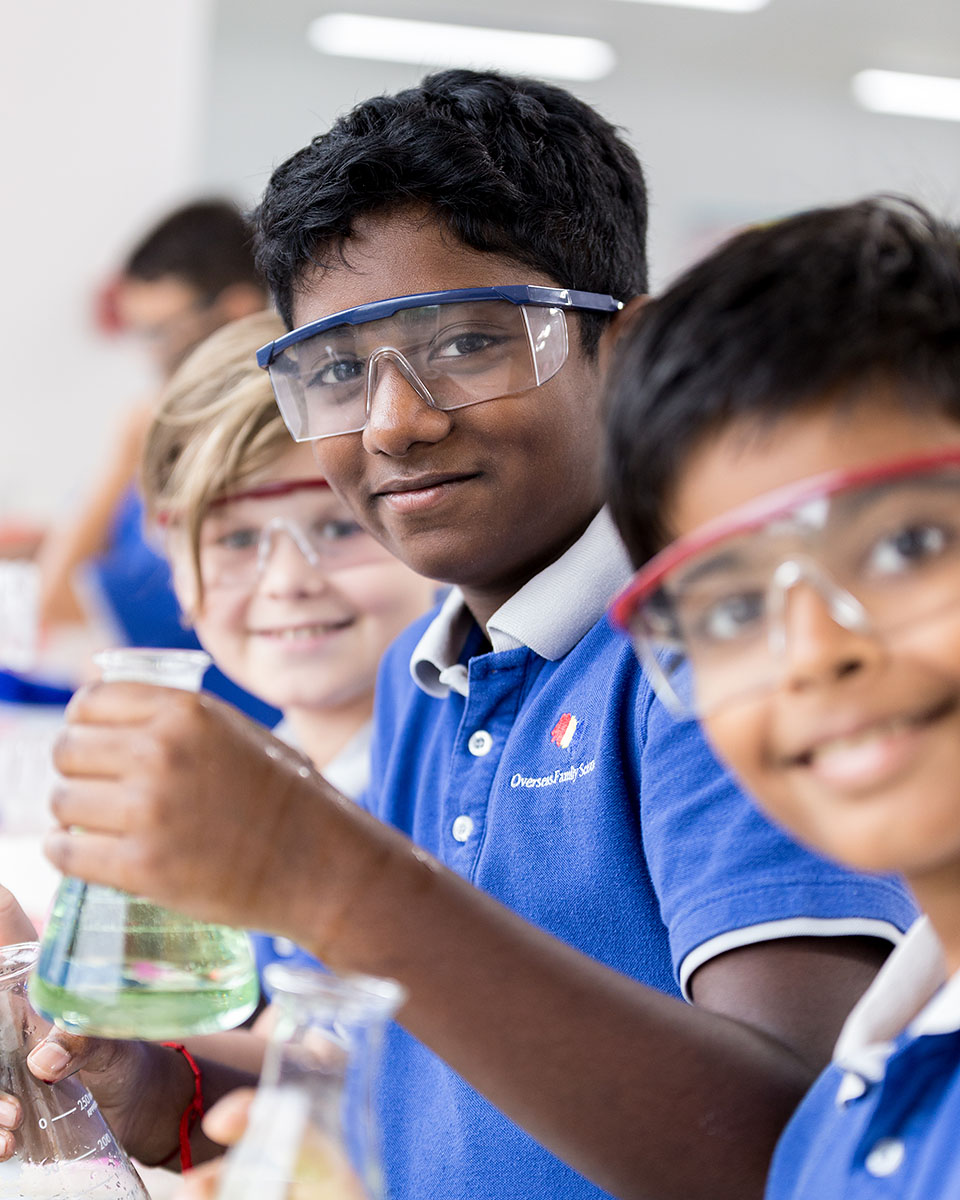 A male OFS Middle School student holding a flask during science lesson in the lab