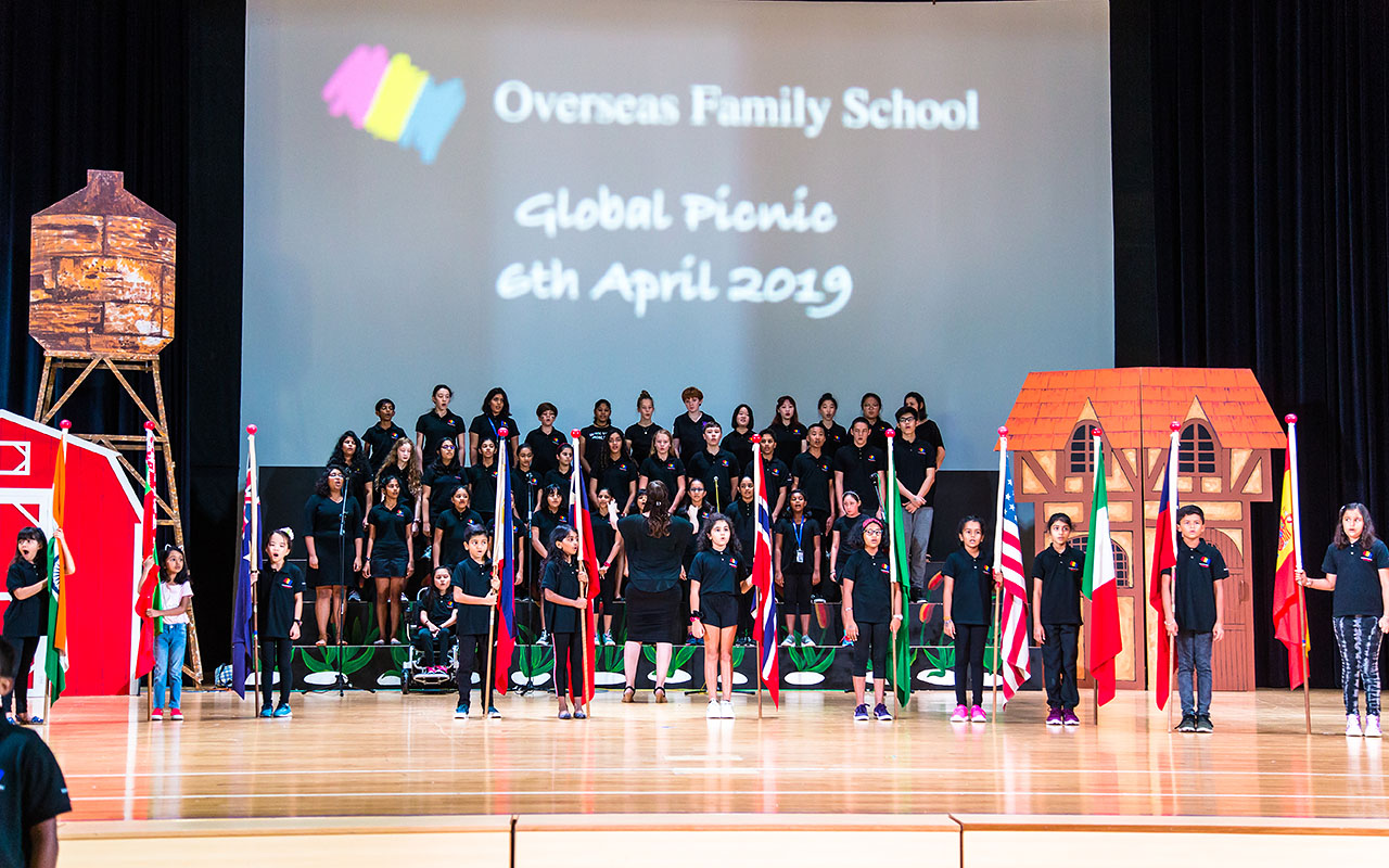 OFS Performance Art club students singing on the auditorium stage during Global Picnic