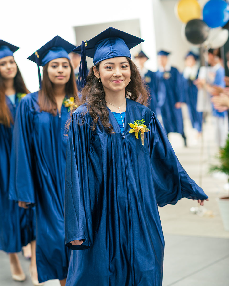 A female OFS High School graduate walking to the auditorium during High School graduation