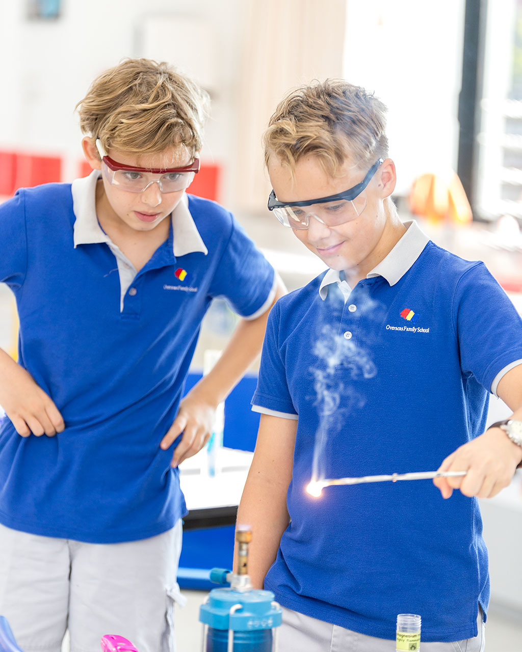 Two male OFS Middle School students wearing eye protectors doing experiment in the Middle School Science Laboratory