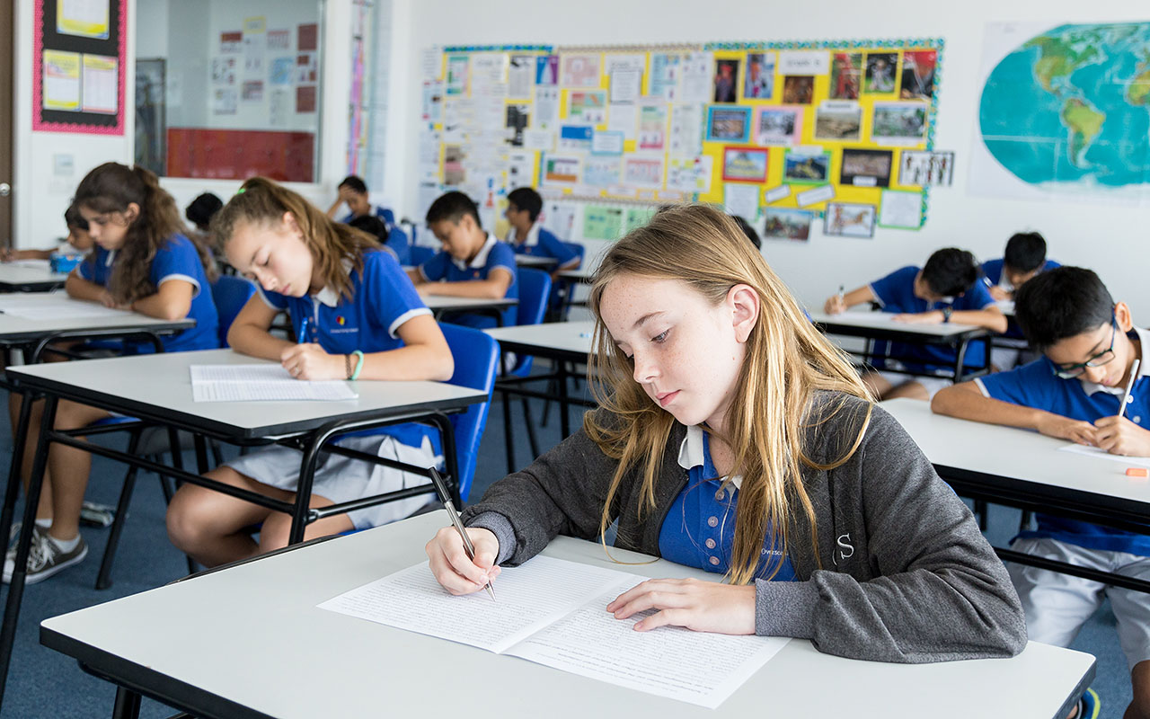 A class full of OFS Middle School students taking notes during lesson in the classroom