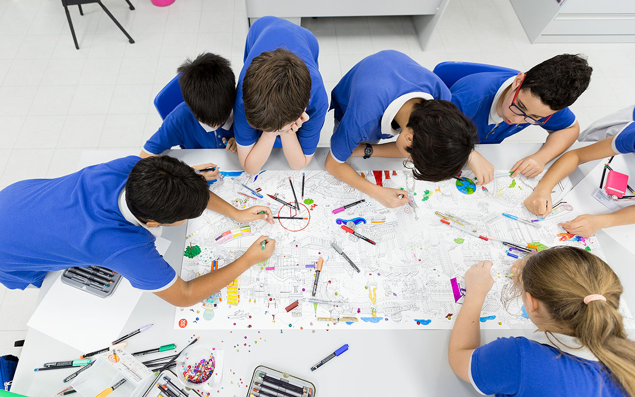 A group of OFS Middle School students coloring the Singapore landmarks map for MADD week art