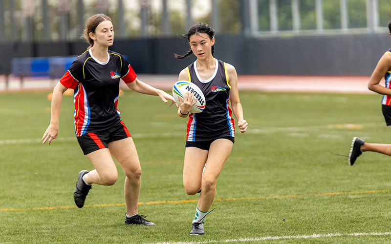 OFS High School girls touch rugby team playing in a match against another school