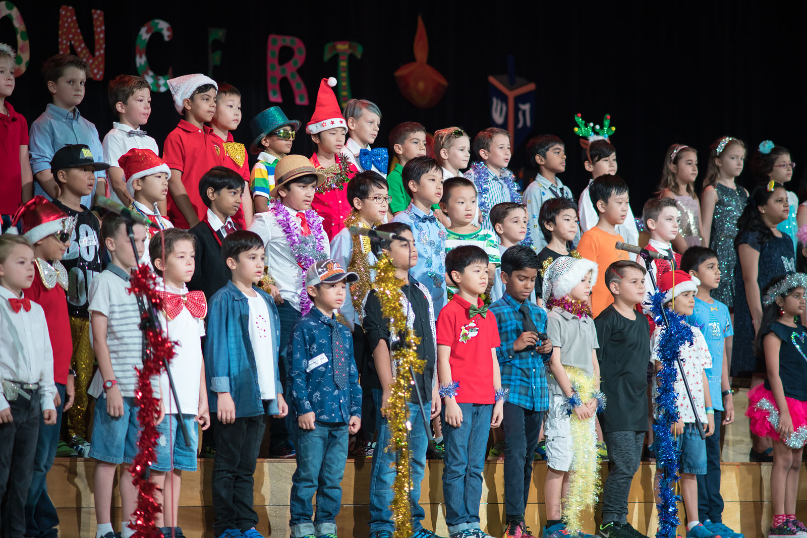 OFS Elementary School students performing on stage in auditorium during Holiday Concert